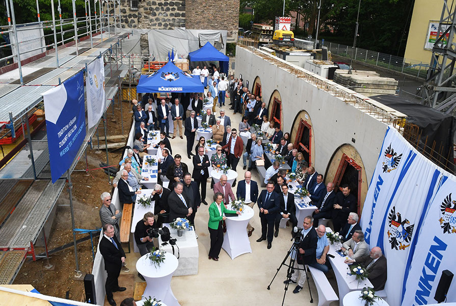 Der “Entlastungsbau wächst in die Höhe: die ersten architektonischen Details sind für die Gäste des ersten Turmfestes erkennbar, denn dieses findet in dem Bereich der Baustelle statt, in dem sich zukünftig der neue Saal im Erdgeschoss befinden wird und der teilweise Formen der mittelalterlichen Stadtmauer aufgreift.
